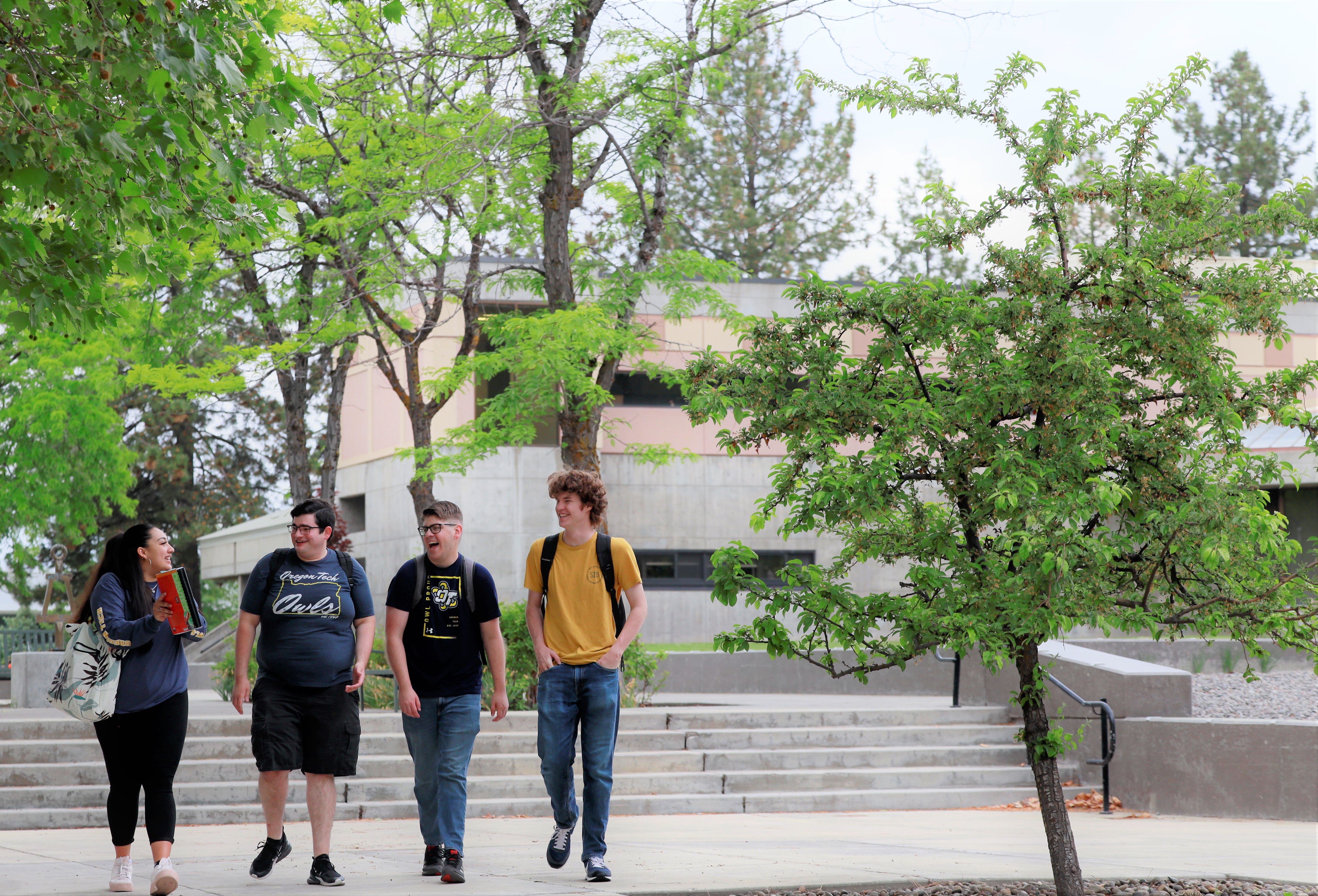 4 students walking across campus