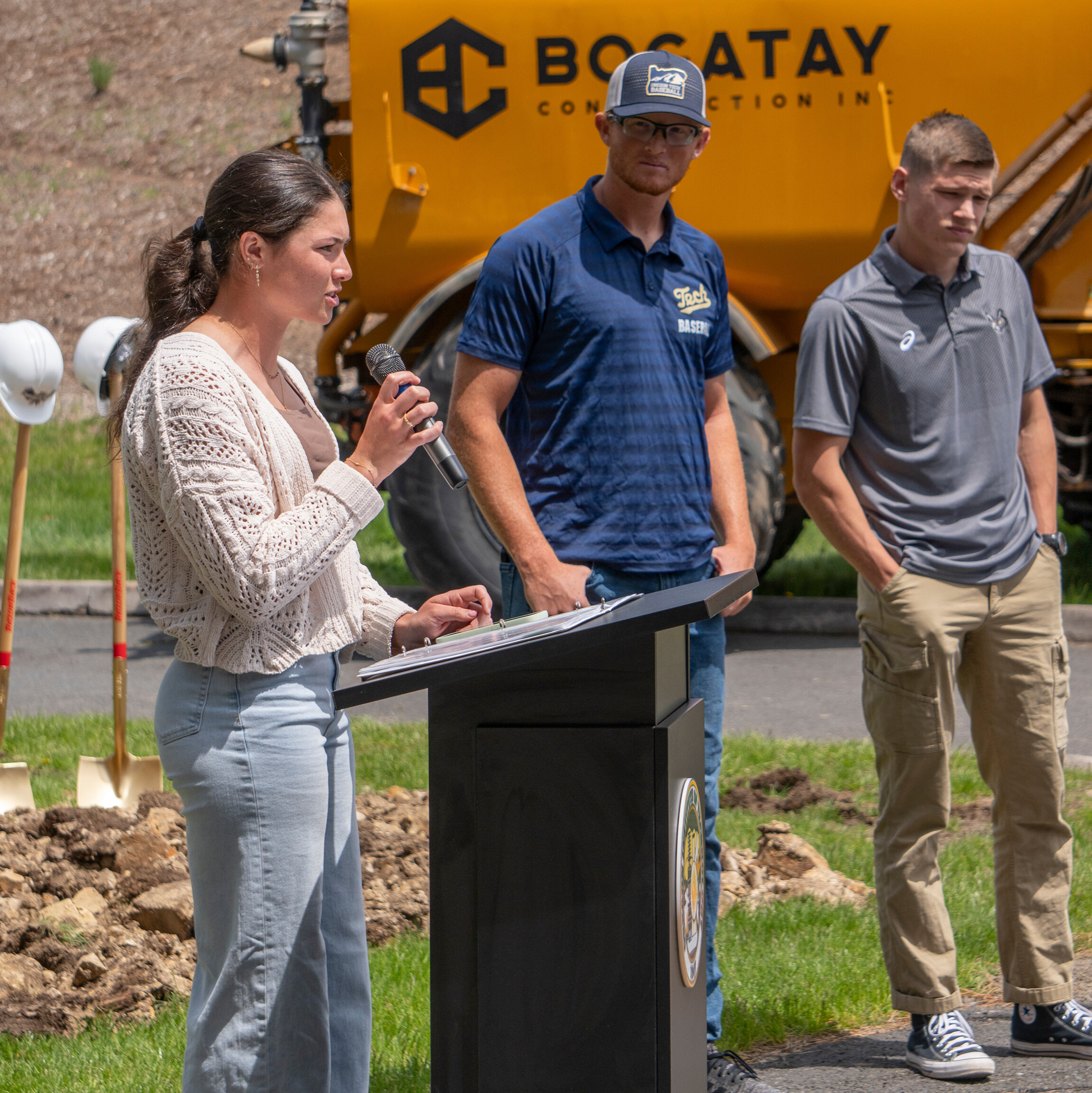 Malia Mick standing at a podium speaking