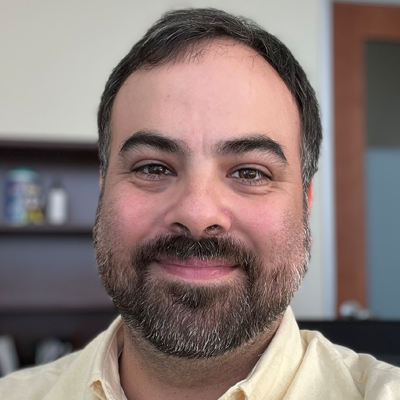 Image of Ryan Henley with short brown hair and light beard with yellow shirt