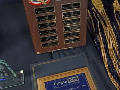 Photo of the perpetual plaque, recipient plaque, and cords for the Outstanding Student Veteran Award.
