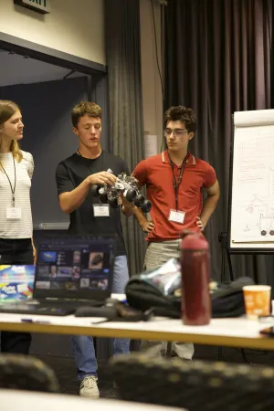 Grayson (center in black shirt) working on robot rover