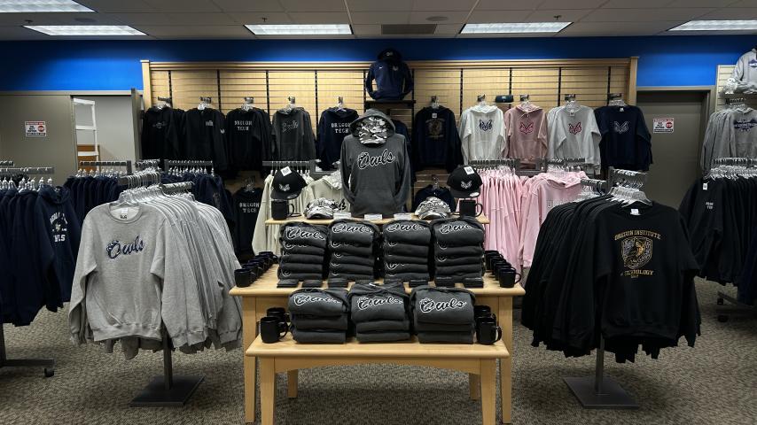 Table and racks with sweatshirts